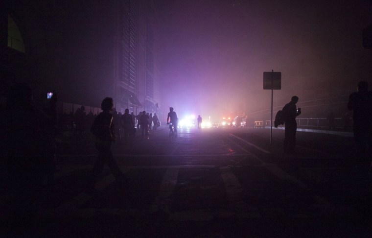 Pedestrians are shown on Boylston Steet after a transformer fire sent black smoke into streets and plunged parts of the city into darkness in the Back Bay section of downtown Boston March 13, 2012. A three alarm fire caused power problems as citizens were warned to avoid the area avoid breathing the smoke according to officials. REUTERS/Scott Eisen (UNITED STATES - Tags: ENERGY SOCIETY)
