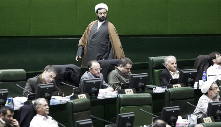 An unidentified Iranian clerical lawmaker walks inside the parliament as legislators listen President Mahmoud Ahmadinejad, unseen, answer questions in an open session in parliament in Tehran, Iran, Wednesday, March 14, 2012. Iran's parliament began Wednesday to question President Mahmoud Ahmadinejad over a long list of accusations, including that he mismanaged the nation's economy and challenged the country's supreme leader. Ahmadinejad is the first president in the country's history to be hauled before the Iranian parliament, a serious blow to his standing in a conflict pitting him against lawmakers. (AP Photo/Vahid Salemi)