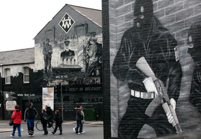 A Titanic related mural (L) is pictured near a Loyalist paramilitary mural (R) in Belfast, Northern Ireland, on March 13, 2012. The world's biggest Titanic visitor attraction is to open in its Belfast birthplace later this month, 100 years to the day since the doomed ocean liner was completed in the same shipyards. Northern Ireland hopes the eye-catching centre will kick-start its tourism economy and encourage travellers from the key emerging markets in Asia to visit to the province. AFP PHOTO/ PETER MUHLY (Photo credit should read PETER MUHLY/AFP/Getty Images)
