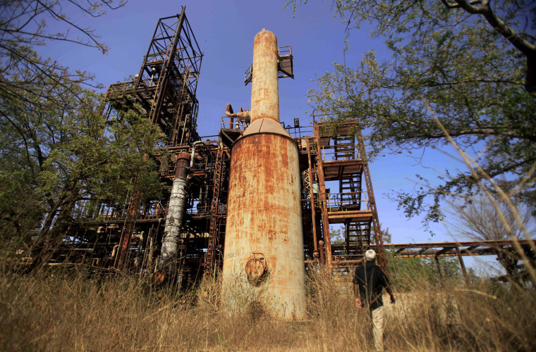 In this photo taken Tuesday, March 13, 2012, the abandoned Union Carbide plant is seen in Bhopal, India. The survivors of the tragedy of 27 years ago, with their lingering illnesses, sick children and dead relatives, faded away from the world's memory, even as their suffering went on. Now, though, they have seized on a new chance to force their plight in front of the world, the London Olympics. (AP Photo/Rafiq Maqbool)