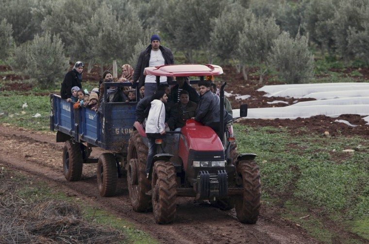 A group of Syrian refugees travel on the back of a tractor, after fleeing violence in their country, as they arrive across the Turkish Syrian border near Reyhanli, Turkey, Thursday, March 15, 2012. Turkey said Thursday it was considering the establishment of a