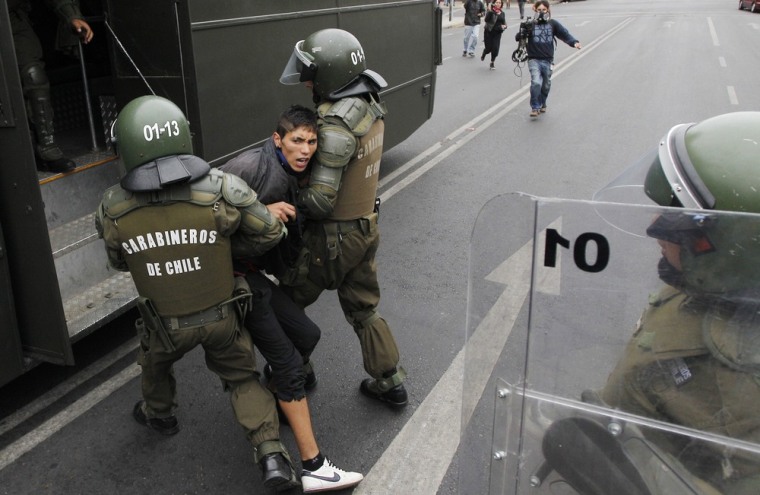 Riot police detain a student during a protest against the government to demand changes in the public state education system in Valparaiso city, about 121 km (75 miles) northwest of Santiago, March 15, 2012. Chilean students have been protesting against what they say is the profiteering in the state education system. REUTERS/Eliseo Fernandez (CHILE - Tags: EDUCATION CIVIL UNREST)