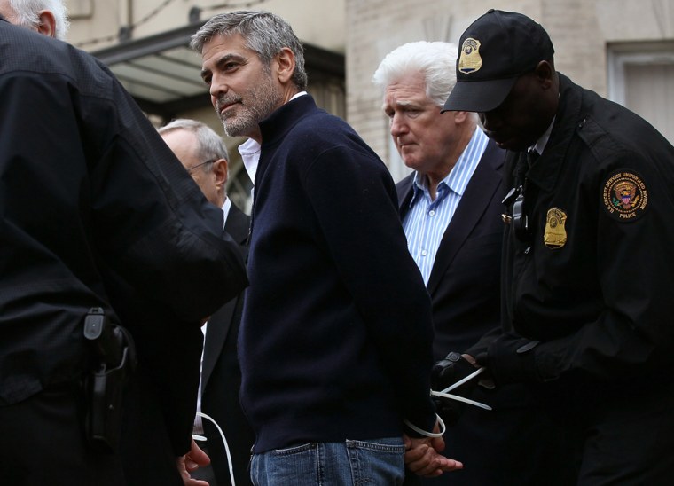 WASHINGTON, DC - MARCH 16:  Actor George Clooney (L) is arrested during a demonstration outside the Embassy of Sudan March 16, 2012 in Washington, DC. United to End Genocide, the Enough Campaign and Amnesty International held a rally to call on the United States and world leaders to stop the violence in South Sudan and prevent hundreds of thousands of people from starving.  (Photo by Win McNamee/Getty Images)