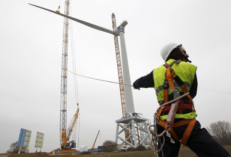 Technicians install a wind turbine blade at Alstom's offshore wind site in Le Carnet, on the Loire Estuary, near Saint Nazaire, March 16, 2012. French power and transport engineering company Alstom will start its new direct drive Haliade 150 - 6MW offshore wind turbine in April. REUTERS/Stephane Mahe (FRANCE - Tags: ENERGY SCI TECH)