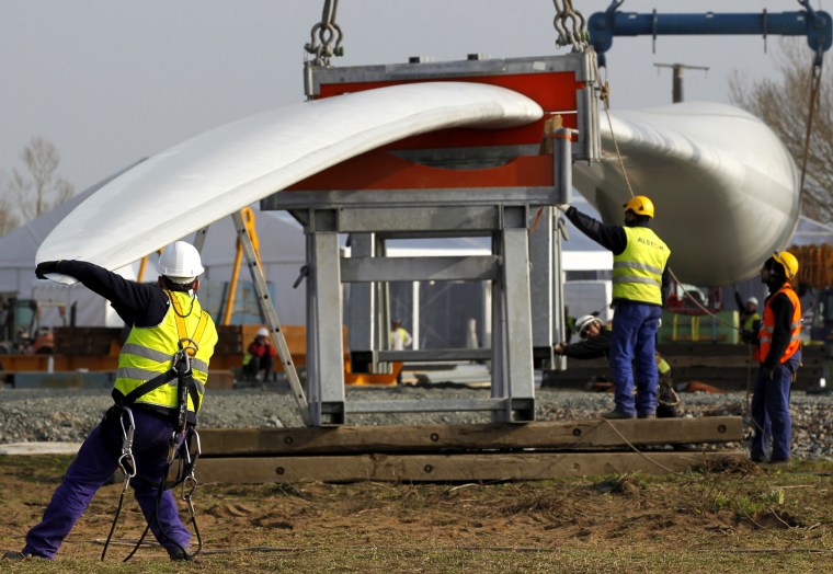Technicians prepare the installation of a wind turbine blade at Alstom's offshore wind site in Le Carnet, on the Loire Estuary, near Saint Nazaire, March 16, 2012. French power and transport engineering company Alstom will start its new direct drive Haliade 150 - 6MW offshore wind turbine in April. REUTERS/Stephane Mahe (FRANCE - Tags: ENERGY SCI TECH)