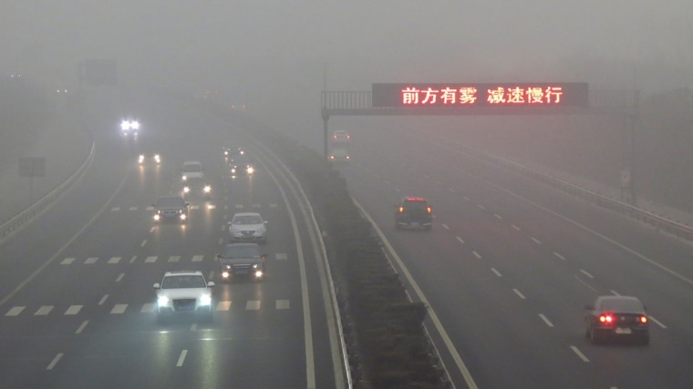 Vehicles make their way along a highway as fog covers most of Beijing on March 17, 2012. More than 400 flights to and from Beijing airport, including around 35 international services, were cancelled or delayed due to thick fog and strong air pollution covering the city, which the US embassy own measuring system, said pollution in Beijing had reached the