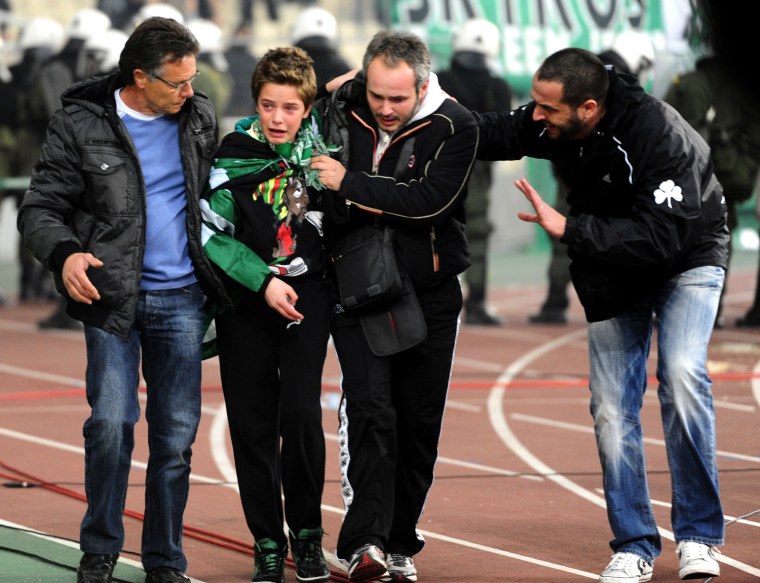 A young supporter of Panathinaikos is carried away from clashes during a Greek Super League football game against Olympiakos at the Athens Olympic stadium on March 18, 2012. AFP PHOTO / ARIS MESSINIS (Photo credit should read ARIS MESSINIS/AFP/Getty Images)