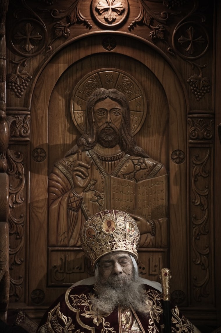 The body of Pope Shenuda III, the spiritual leader of the Middle East's largest Christian minority, sits dressed in formal robes on a wooden throne at the Saint Mark's Coptic Cathedral in Cairo's al-Abbassiya district, for the people to bid farewell to him on March 19, 2012. Pope Shenuda died at the age of 88, after a long battle with illness and based on his wishes he will be buried on March 20, at St. Bishoy monastery in Wadi Natrun in the Nile Delta where he spent his time in exile after a dispute with late president Anwar Sadat.AFP PHOTO/GIANLUIGI GUERCIA (Photo credit should read GIANLUIGI GUERCIA/AFP/Getty Images)