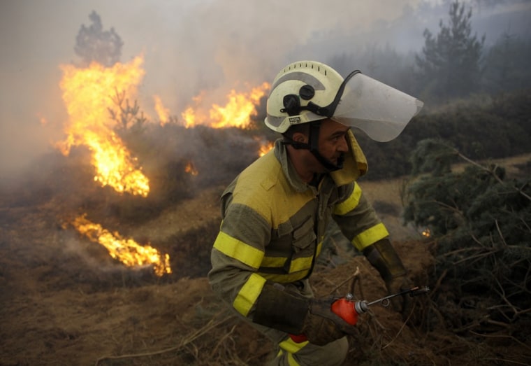 A firemen runs close to a fire burning near the village of Castrelo do Val, in Ourense, northwestern Spain, on March 27, 2012. A firefighter was killed fighting one of the wildfires that have devastated thousands of acres due to drought in Galicia, northwestern Spain. AFP PHOTO / MIGUEL RIOPA (Photo credit should read MIGUEL RIOPA/AFP/Getty Images)