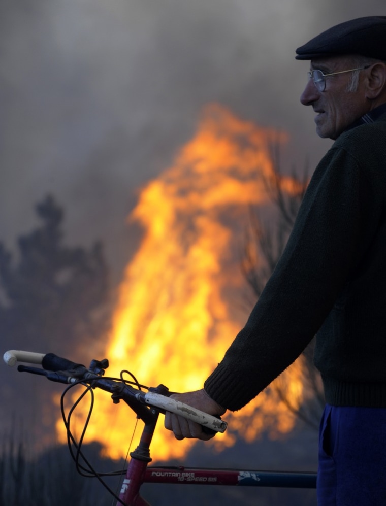 A villager looks at a fire burning close to the village of Castrelo do Val, near Ourense, northwestern Spain, on March 27, 2012. A firefighter was killed fighting one of the wildfires that have devastated thousands of acres due to drought in Galicia, northwestern Spain. AFP PHOTO / MIGUEL RIOPA (Photo credit should read MIGUEL RIOPA/AFP/Getty Images)