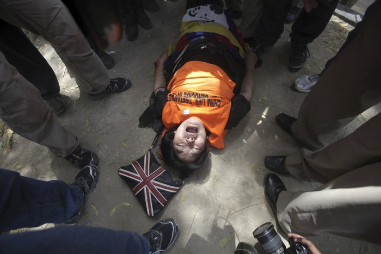 A Tibetan exile shouts slogans while lying on the ground during a protest against the visit of Chinese President Hu Jintao to India, in New Delhi March 28, 2012. Hu is scheduled to attend the BRICS (Brazil, Russia, India, China and South Africa) Summit in India on March 29. REUTERS/Adnan Abidi (INDIA - Tags: POLITICS CIVIL UNREST)