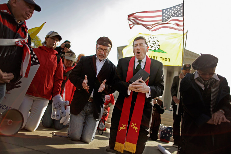 Rev. Rob Schneck and Rev. Patrick Mahoney lead people in prayer outside the U.S. Supreme Court on the third day of oral arguments over the constitutionality of the Patient Protection and Affordable Care Act on March 28 in Washington, DC. Today is the last of three days the high court set to hear arguments over the act.