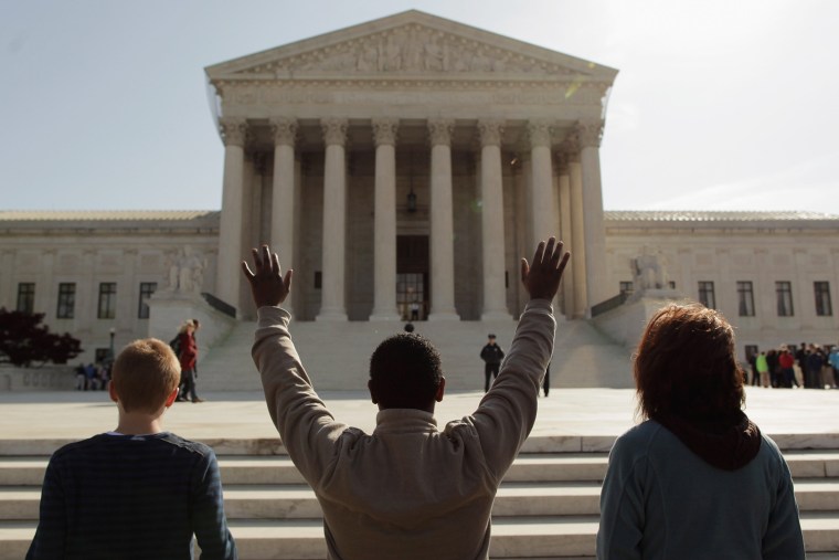 Members of the anti-abortion group Bound4Life pray outside the U.S. Supreme Court on the third day of oral arguments over the constitutionality of the Patient Protection and Affordable Care Act on March 28 in Washington, DC. Today is the last of three days the high court set to hear arguments over the act.