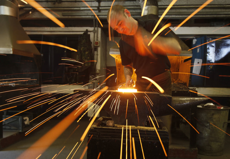 Corporal McCabe, a farrier with the mounted regiments of the Household Cavalry, shapes a horse's shoe, during a media day at the barracks in London.