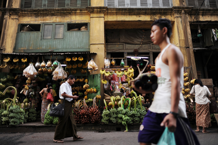 Residents walk past shops selling bananas in Yangon on March 29. More than two decades after its stolen election win, Aung San Suu Kyi's opposition party is set for a dramatic political comeback in Myanmar polls which could herald an easing of sanctions.