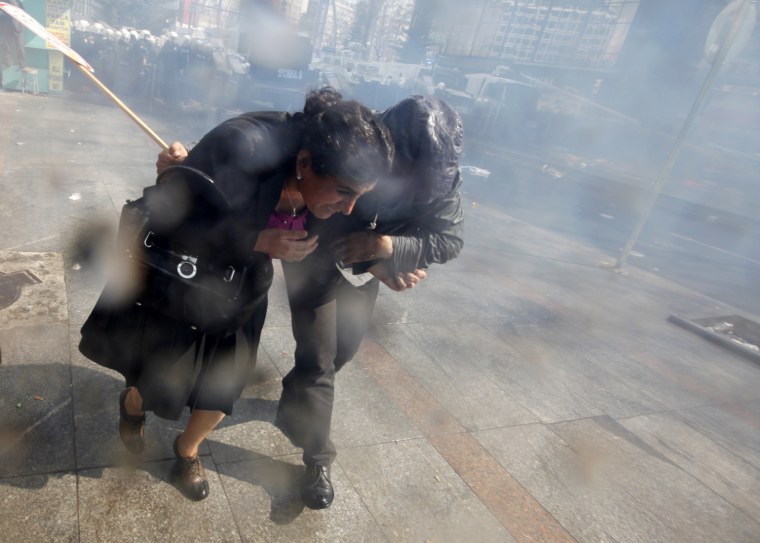 Sebahat Tuncel, a Kurdish member of parliament, runs for cover as riot police disperse demonstrators during a protest against a government attempt to railroad a new education bill through parliament in Ankara March 29. Members of teachers' union and opposition supporters gathered in the Turkish capital of Ankara to protest against a government attempt to railroad the new education bill through parliament which secular parties say is designed to promote Islamic schooling. The government wants to overturn a 1997 law imposed with the backing of the military which extended compulsory education from five to eight years, but also stopped under-15s attending religious