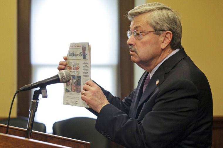 Iowa Gov. Terry Branstad holds up a copy of the Des Moines Register as he and other meat industry supporters fought back against what they called a smear campaign by consumer activists seeking a ban on meat scraps added to hamburger.