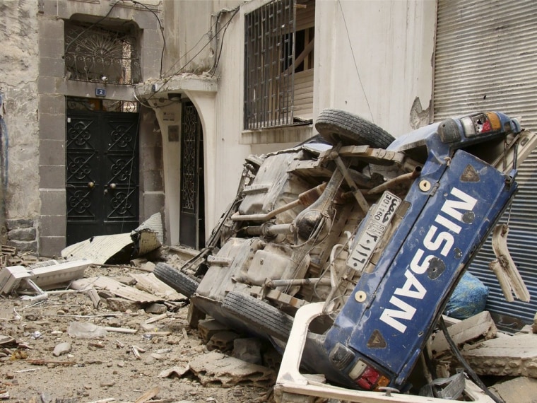 A damaged car is seen in front of a damaged building in the old city of Homs, Syria, March 30.