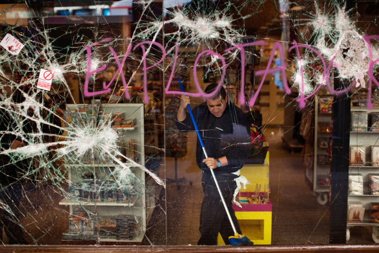 A worker cleans a shop stormed by demonstrators following clashes between police and protesters after a general strike in Barcelona, Spain, on March 30. The Spanish government prepared to approve on Friday a new austerity budget that hundreds of thousands protested against this week in sometimes violent demonstrations.