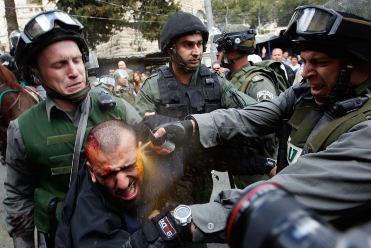 Israeli border police officers use pepper spray as they detain an injured Palestinian protester during clashes on Land Day after Friday prayers outside Damascus Gate in Jerusalem's Old City on March 30.