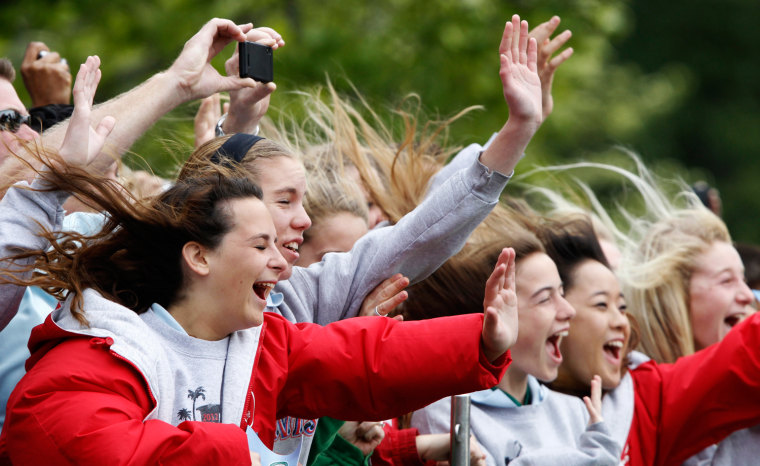 Visitors brace themselves from the rotor wash of the Marine One helicopter as President Barack Obama lifts off from the South Lawn of the White House in Washington, on March 30, as he travels to Vermont and Maine for campaign fundraising events.