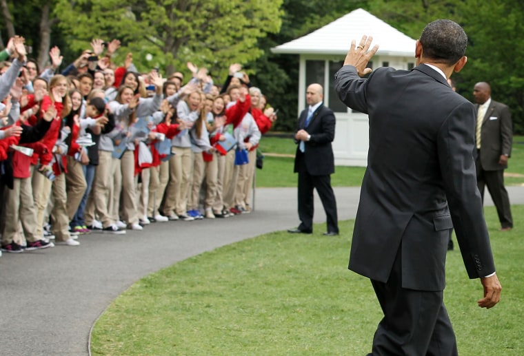 U.S. President Barack Obama waves to visitors as he walks towards the Marine One on the South Lawn prior to his departure from the White House March 30, in Washington, DC. Obama was traveling to Vermont and Maine for campaign events.
