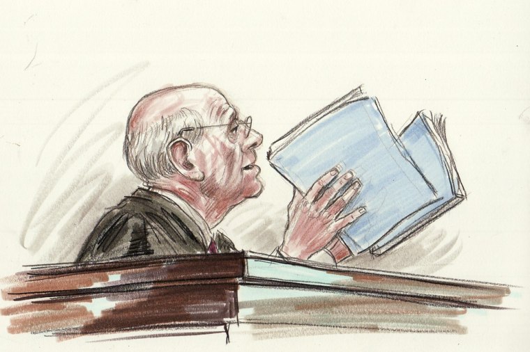 Justice Stephen Breyer holds two sections of the Affordable Care Act during a third day of arguments over the fate of the health care law.
