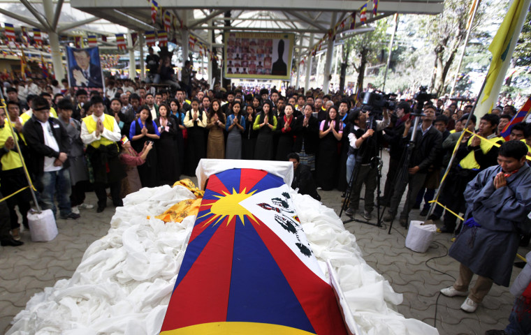 Tibetan exiles offer prayers near the coffin containing the body of 27-year-old Jamphel Yeshi, wrapped in a Tibetan flag, inside the Tsuglakhang temple, in Dharmsala on March 30.