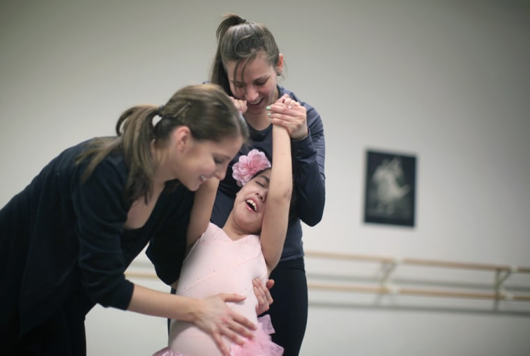 Samara Almanza (C) is helped with her stretching by Kaitlyn Pasquinelli (L) and Ilana Feld during the dance class.