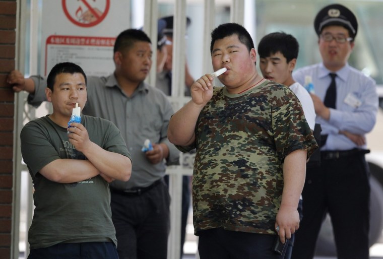 Men guarding building G of Chaoyang Hospital, where blind rights activist Chen Guangcheng was reported to be staying, eat ice-cream at the entrance of the hospital in Beijing Saturday.