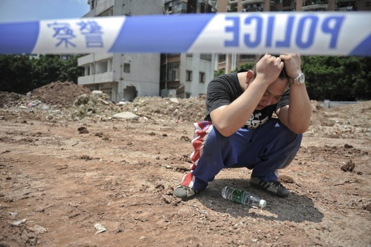 Xian Xiyong cries after his mother, Li Jie'e, jumped off a building and died at a demolition site in Yangji village in Guangzhou, Guangdong province, China on May 10, 2012.