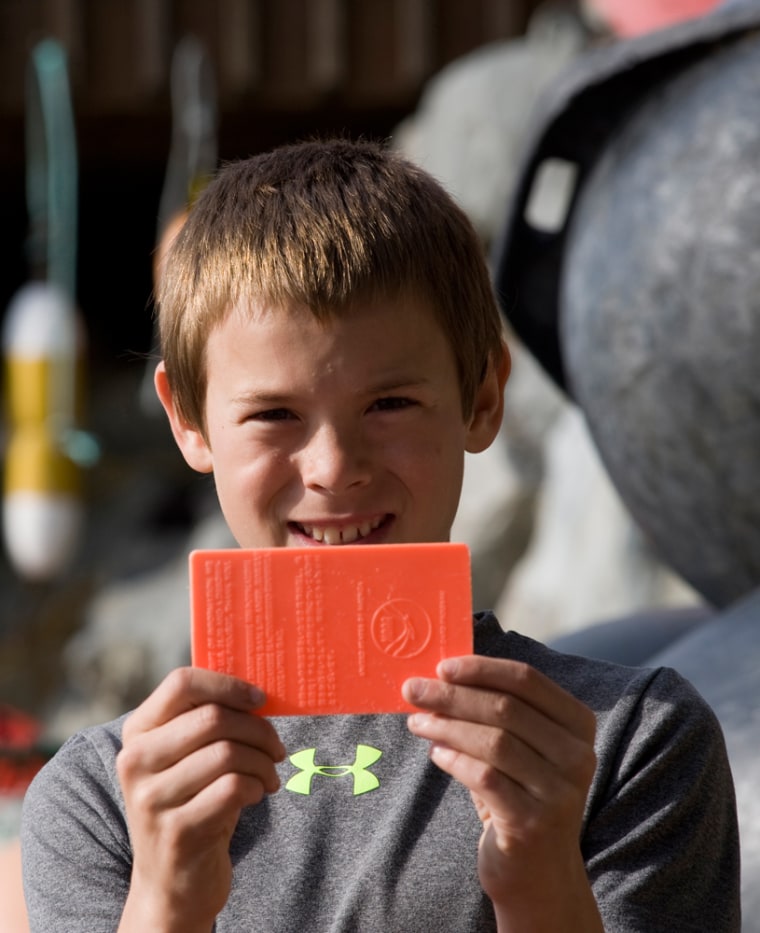Beachcomber Emmitt Andersen, 12, holds up a plastic card set adrift by NOAA in the 1970s that he found in Sitka, Alaska.
