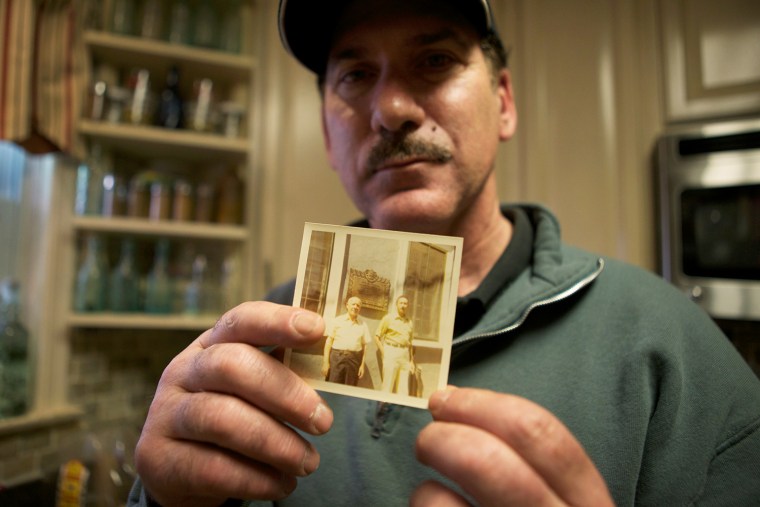 Standing in the kitchen of his Parkside Hills home in New York, Walter Backerman holds a picture of his father and grandfather.