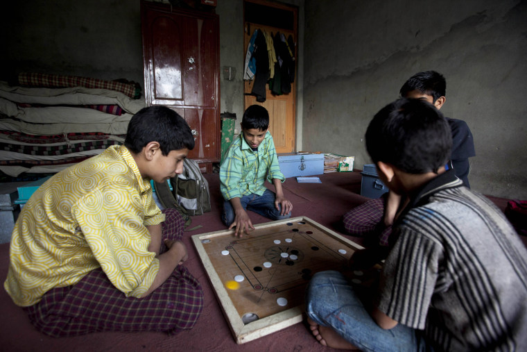 Kashmiri orphan boys play a game of carrom inside their room at Gulshan Mahal Orphanage in Srinagar, India on May 10.