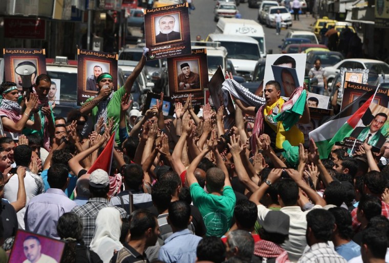 Palestinian protesters hold portraits of their relatives held in Israeli jails during a demonstration to show solidarity with Palestinian prisoners on hunger strike, in the West Bank city of Ramallah on Friday.