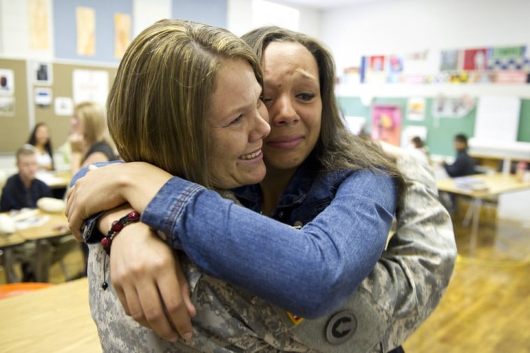 U.S. Army Sgt. 1st Class Carrie Stewart hugs her daughter Tiara Sanders, 14, after surprising the Bolton High School freshman in class on Friday in Bolton, Tenn.. Stewart just finished a 10 month deployment in Kuwait and was not scheduled to return to the U.S. for three more weeks.