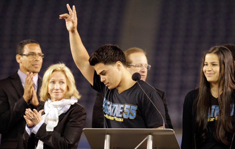 Tyler Seau, center, the son of Junior Seau, reacts to fans during a public memorial service for his father on Friday night.