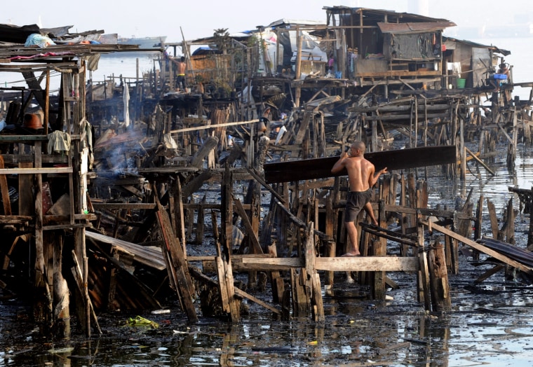 Residents search for usable items at the site of a fire in a shanty town in Manila.