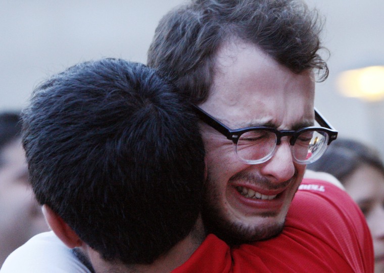 Boston University student Blake Wrobbel, of Los Angeles, right, gets emotional during the vigil.