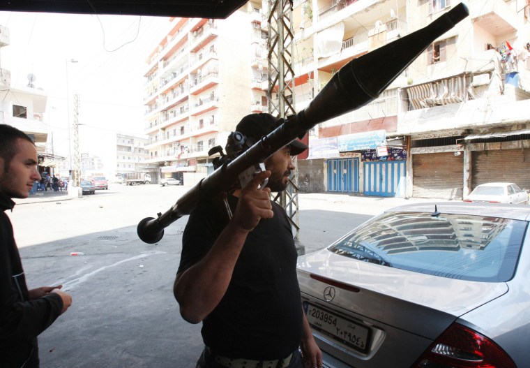 A Sunni Muslim gunman carries a machinegun during clashes at the Sunni Muslim Bab al-Tebbaneh neighbourhood in Tripoli, northern Lebanon, on May 14. Two men were killed and at least 20 were wounded in clashes between Alawite supporters of Syrian President Bashar al-Assad and Sunni Muslim fighters in the Lebanese city of Tripoli, medical sources said on Monday. Fierce clashes overnight shook the northern port city and sporadic fighting continued on Monday morning, with fighters firing machineguns and rocket propelled grenades.