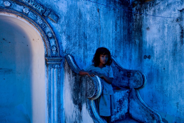 A displaced Muslim girl takes up shelter at a destroyed mosque after fleeing a government offensive against the Tamil Tigers in Nanathan, Sri Lanka, September 2007.