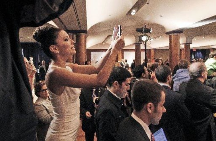 Actress Eva Longoria uses her cell phone to take a picture of President Barack Obama as he speaks at a fundraiser.