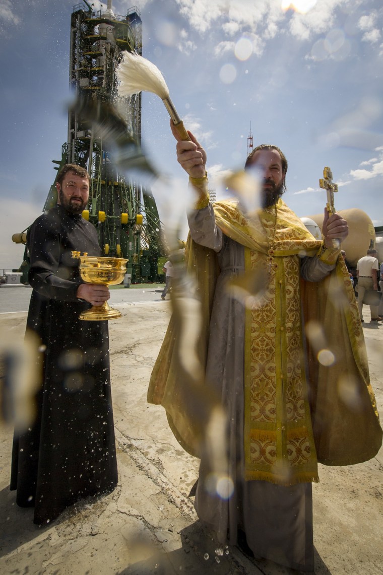 An Orthodox Christian priest blesses members of the media shortly after blessing the Soyuz rocket at the Baikonur Cosmodrome Launch pad Monday.