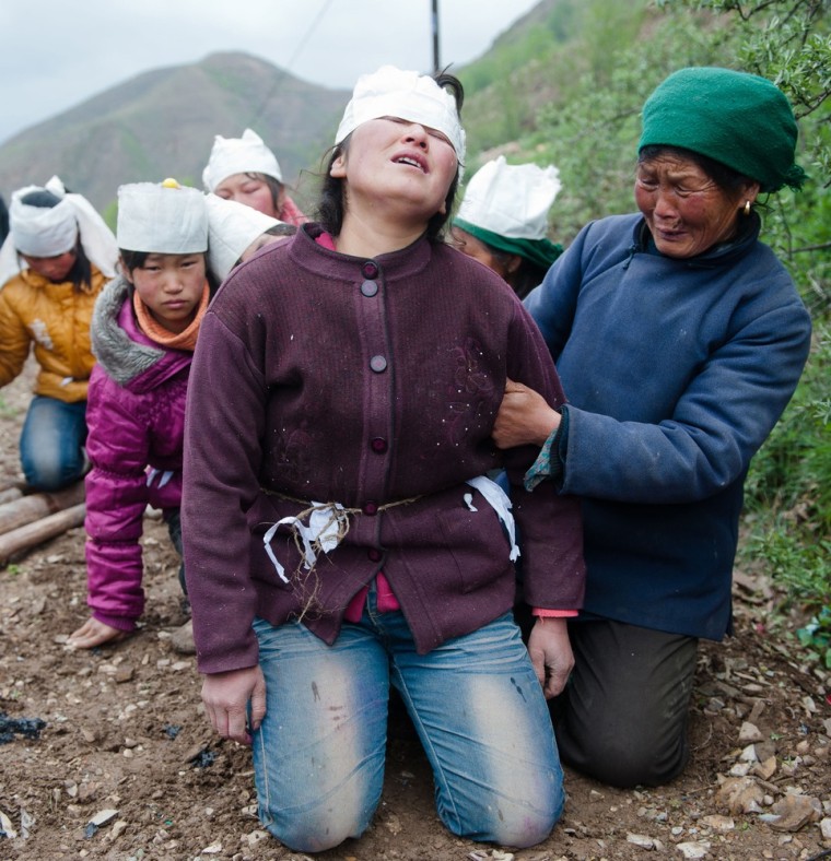 Family members grieve during a funeral for the victims of the violent hailstorm and torrential rain that swept through Minxian in northwestern China's Gansu province. Pictures taken on May 13, 2012 and made available today.