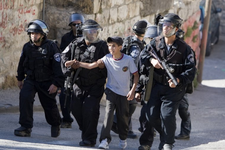 Israeli riot policemen arrest a Palestinian boy in the east Jerusalem Arab neighborhood of Issawiya on May 15, 2012.