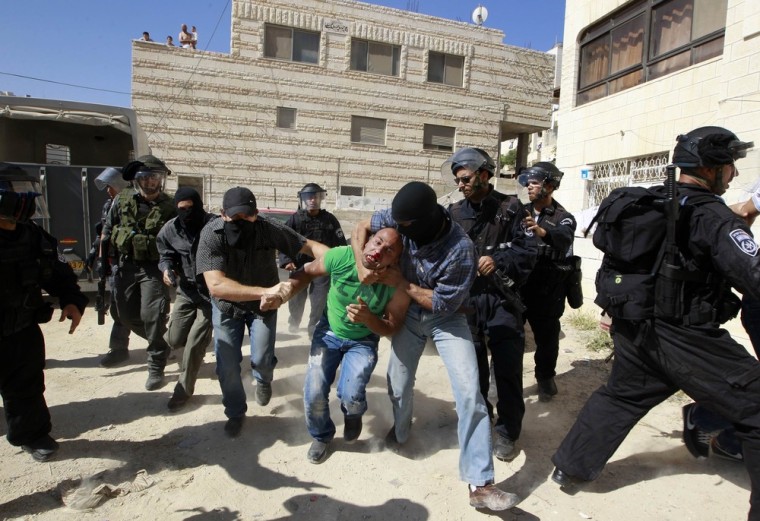A Palestinian suspected of throwing stones is detained by undercover Israeli police officers in the East Jerusalem neighbourhood of Issawiya May 15, 2012.