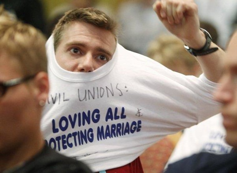 A supporter of the Civil Unions bill puts on a T-shirt in the House State Affairs Committee, where testimony was being heard at the Capitol in Denver on Monday, May 14, 2012.
