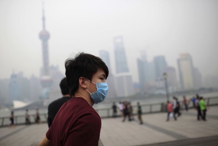 A young man wearing a mask walks along the Bund in Shanghai on May 15, 2012.