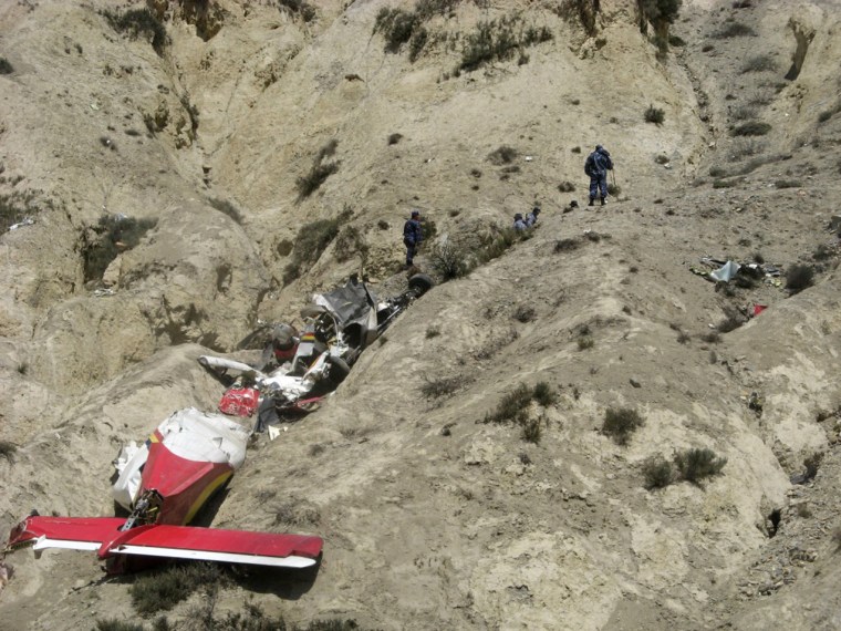 Onlookers and rescuers are seen near the wreckage of an Agni Air Dornier Do 228 aircraft at the crash site in Jomsom, west of Kathmandu, on May 14, 2012.  A small plane crashed near a treacherous high-altitude airport in northern Nepal May 14, killing 15 people while six others miraculously survived, police said. The aircraft belonging to local carrier Agni Air ploughed into the ground just outside Jomsom airport, a gateway to the Annapurna mountain range, shortly after the pilot reported a fault.