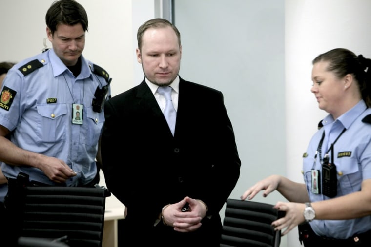 Anders Behring Breivik stands between two police officers prior to taking his seat after a break in the courtroom in Oslo on May 15, 2012.